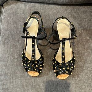 Black Gucci cork sandals with patent leather straps.